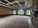 Spacious living room featuring a coffered ceiling, stone fireplace, and large arched windows at 8503 Kentucky Derby Dr, Odessa, FL 33556