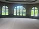 Large living room featuring oversized arched windows and neutral-toned carpet at 8503 Kentucky Derby Dr, Odessa, FL 33556