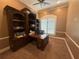 Office space featuring a large wooden desk, built-in bookshelves, and plantation shutters at 8503 Kentucky Derby Dr, Odessa, FL 33556