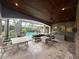 Covered patio with outdoor kitchen, fireplace, and ample seating overlooks the pool at 8503 Kentucky Derby Dr, Odessa, FL 33556