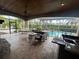 Screened-in patio with outdoor kitchen, fireplace, and seating overlooks the pool area at 8503 Kentucky Derby Dr, Odessa, FL 33556