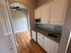 This interior photo shows a wet bar with white cabinets, a sink, and a mini-fridge at 8503 Kentucky Derby Dr, Odessa, FL 33556