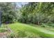 Lush backyard featuring a serene view, mature trees, and a spacious grassy area at 19308 Sunset Bay Dr, Land O Lakes, FL 34638