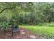 Secluded backyard featuring mature trees, landscaping, and a quaint patio area at 19308 Sunset Bay Dr, Land O Lakes, FL 34638