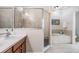 Bathroom features a tiled walk-in shower, soaking tub, and wood vanity with a sink and chrome faucet at 19308 Sunset Bay Dr, Land O Lakes, FL 34638