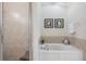 Bathroom soaking tub with tile surround, chrome fixtures, and framed artwork create a relaxing spa-like atmosphere at 19308 Sunset Bay Dr, Land O Lakes, FL 34638
