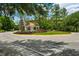 Welcoming community entrance with lush landscaping, red roofed building, and a roundabout at 19308 Sunset Bay Dr, Land O Lakes, FL 34638