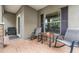 Cozy front porch features brick flooring, neutral tones, rocking chairs, and ample sunlight at 19308 Sunset Bay Dr, Land O Lakes, FL 34638