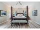 Bright main bedroom features a four-poster bed with decorative pillows, wood flooring and lots of natural light at 19308 Sunset Bay Dr, Land O Lakes, FL 34638