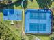 Aerial view of a basketball and two tennis courts in a fenced-in area with landscaping and nearby path at 19308 Sunset Bay Dr, Land O Lakes, FL 34638