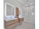 Modern bathroom featuring double sinks, lit mirrors, wood cabinets, and a luxurious walk-in shower with white marble tile at 2 Aqua Reserve Blvd, New Port Richey, FL 34652