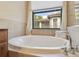 Bathroom featuring a large oval tub, bright window, and neutral tile at 20312 Heritage Point Dr, Tampa, FL 33647