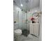 Bathroom featuring a modern glass corner shower, white vanity, round mirror, and grey tile floor at 2540 W Pine St, Tampa, FL 33607