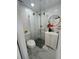 Bathroom featuring a modern glass corner shower, white vanity, round mirror, and grey tile floor at 2540 W Pine St, Tampa, FL 33607