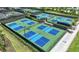 Aerial view of multiple pickleball courts with blue and green surfaces and surrounding landscaping at 26836 Dove Dr, Punta Gorda, FL 33955
