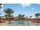Relaxing community pool with fountains, umbrellas, lounge seating, and palm trees at 26836 Dove Dr, Punta Gorda, FL 33955