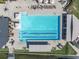 Aerial view of the rectangular pool featuring lap lanes, lounge chairs, tables, and umbrellas on a paved pool deck at 5836 Skimmer Point S Blvd, Gulfport, FL 33707