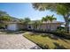 Well-manicured home with lush landscaping, a circular driveway, and a pristine exterior at 5836 Skimmer Point S Blvd, Gulfport, FL 33707