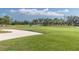 Scenic view of the lush golf course with a sand trap and palm trees in the distance at 5836 Skimmer Point S Blvd, Gulfport, FL 33707
