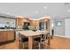Open kitchen with a center island, bar stools, stainless steel appliances, wood cabinetry, and tile backsplash at 5836 Skimmer Point S Blvd, Gulfport, FL 33707