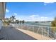 Balcony overlooking a waterfront view with palm trees and a white metal railing at 727 Key Royale Dr, Holmes Beach, FL 34217