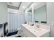 Bathroom featuring a double sink vanity with light blue walls, patterned shower curtain and tile flooring at 727 Key Royale Dr, Holmes Beach, FL 34217