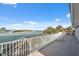 Stunning waterfront views from this home's spacious wooden deck with white railing and chair seating at 727 Key Royale Dr, Holmes Beach, FL 34217
