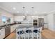 Modern white kitchen featuring an island with seating and stainless steel appliances at 727 Key Royale Dr, Holmes Beach, FL 34217