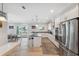 Well-lit kitchen showcases stainless steel appliances, an island, and an adjacent dining area at 727 Key Royale Dr, Holmes Beach, FL 34217