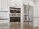Close-up of kitchen appliances including a built-in oven, microwave, and stainless steel refrigerator at 727 Key Royale Dr, Holmes Beach, FL 34217
