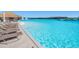 The lagoon features many lounge chairs and clear turquoise water on a clear sunny day at 7673 Yale Harbor Dr, Wesley Chapel, FL 33545