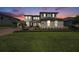 Beautiful home showcasing fresh landscaping, a brick driveway, and elegant exterior lighting at 7721 Roma Dune Dr, Wesley Chapel, FL 33545