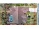 Aerial view of the roof with an in-ground pool and beautiful landscaping around property at 8208 Rhanbuoy Rd, Spring Hill, FL 34606
