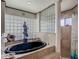 Modern bathroom features a deep soaking tub, walk-in shower, and custom glass block windows at 8208 Rhanbuoy Rd, Spring Hill, FL 34606