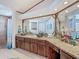 Luxurious bathroom featuring dual sinks, granite countertops, and a walk-in shower at 8208 Rhanbuoy Rd, Spring Hill, FL 34606