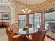 Sunlit dining room with wicker chairs and glass table, offering views of the outdoor pool area at 8208 Rhanbuoy Rd, Spring Hill, FL 34606