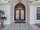 Elegant double front door with decorative glass details and covered porch at 8208 Rhanbuoy Rd, Spring Hill, FL 34606