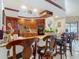 Kitchen bar with stainless steel sink, granite countertops, wood cabinetry, bar seating and views to the kitchen at 8208 Rhanbuoy Rd, Spring Hill, FL 34606
