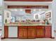 Kitchen bar with stainless steel sink, granite countertops, wood cabinetry and bar seating in an open-concept home at 8208 Rhanbuoy Rd, Spring Hill, FL 34606