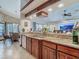 Kitchen bar with stainless steel sink, granite countertops, wood cabinetry and views to the dining area at 8208 Rhanbuoy Rd, Spring Hill, FL 34606