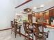 Kitchen bar with stainless steel sink, granite countertops, wood cabinetry, bar seating and views to the kitchen at 8208 Rhanbuoy Rd, Spring Hill, FL 34606