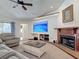 Inviting living room with fireplace, large television, neutral carpet, ceiling fan, and comfortable furniture at 8208 Rhanbuoy Rd, Spring Hill, FL 34606