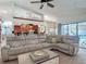 Bright living room with vaulted ceiling, open concept kitchen, large sectional sofa, and sliding glass doors at 8208 Rhanbuoy Rd, Spring Hill, FL 34606