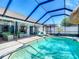 Beautiful in-ground pool with clear water, a screened enclosure, and lounge seating at 8208 Rhanbuoy Rd, Spring Hill, FL 34606