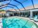 A screened pool with a sun umbrella and outdoor kitchen provide relaxing outdoor living at 8208 Rhanbuoy Rd, Spring Hill, FL 34606