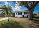 Charming single-story home boasts a well-maintained front yard with mature trees and vibrant blue shutters at 10022 Lily N St # N, Pinellas Park, FL 33782