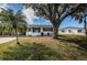 Charming single-story home with blue shutters, lush lawn, and mature trees on a sunny day at 10022 Lily N St # N, Pinellas Park, FL 33782