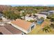 Aerial view shows neighborhood homes with mature trees and green lawns in the background at 18605 Le Dauphine Pl, Lutz, FL 33558