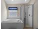 Modern bathroom with separate shower stall and garden tub near a bright window at 18605 Le Dauphine Pl, Lutz, FL 33558