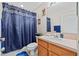 Bathroom featuring a shower with blue curtain, toilet, sink with vanity, and mirror at 18605 Le Dauphine Pl, Lutz, FL 33558